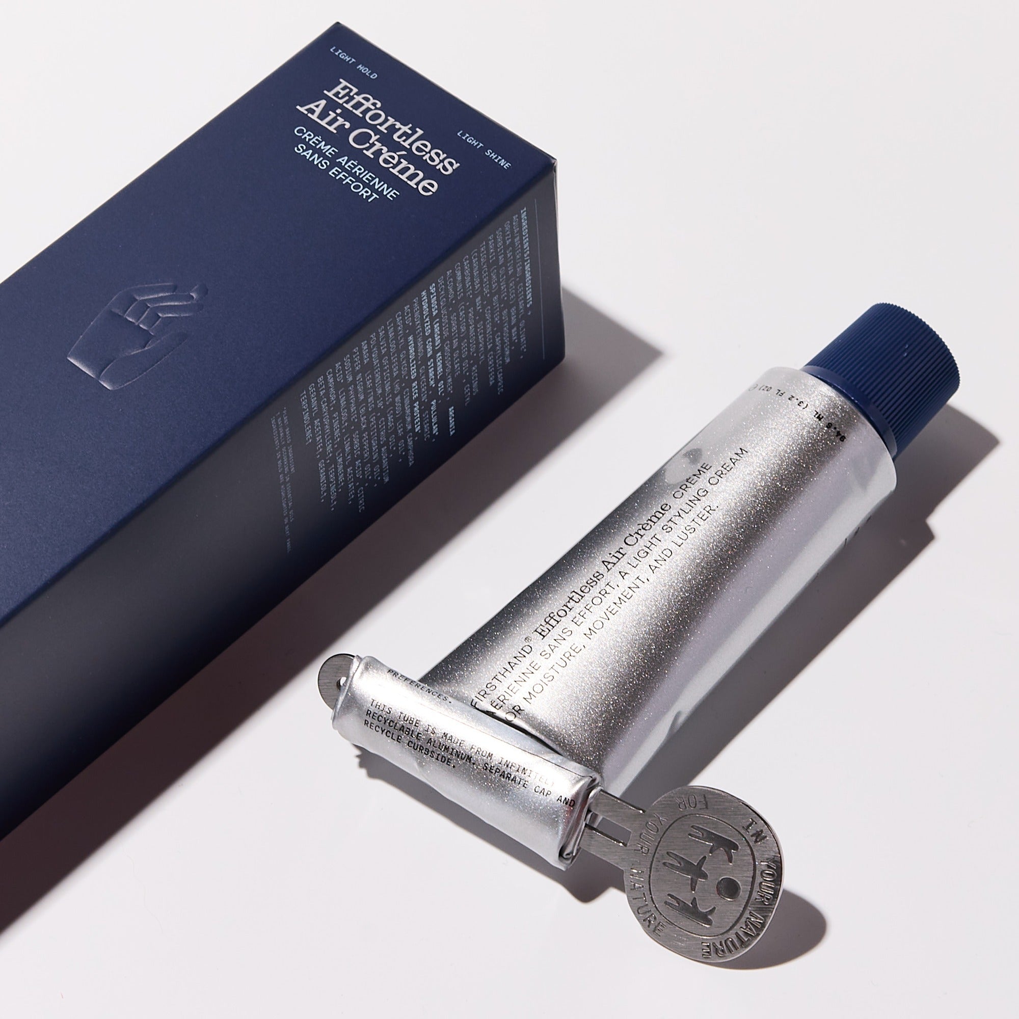 The squeeze key rolled onto the end of an Air Crème tube, next to its box