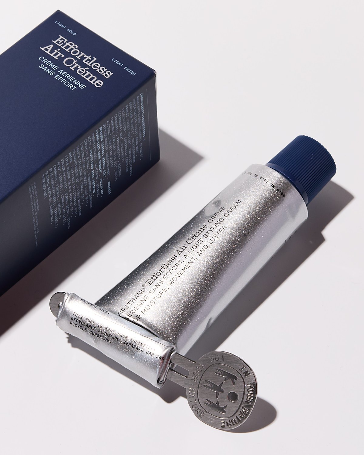 Effortless Air Crème tube rolled up with the squeeze key, next to its box